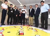 The Secretary for Innovation and Technology, Mr Nicholas W Yang (third right), receives a brief introduction from students of SKH Tang Shiu Kin Secondary School on their STEM (science, technology, engineering and mathematics) activities during his visit to Wan Chai District today (May 27). Also present are the Under Secretary for Innovation and Technology, Dr David Chung (second right); the Chairman of the Wan Chai District Council, Mr Stephen Ng (first right); and the District Officer (Wan Chai), Mr Rick Chan (fourth left).