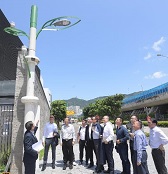 Members of the Multi-functional Smart Lampposts Technical Advisory Ad Hoc Committee inspect the internal structure and smart devices of smart lampposts on Shing Kai Road in Kai Tak after the second meeting today (September 10).