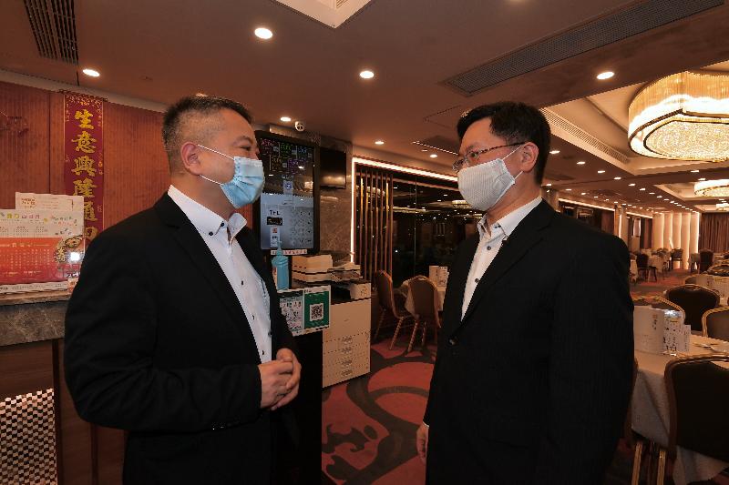The Secretary for Innovation and Technology, Mr Alfred Sit (right), visited a Chinese restaurant in Kowloon City today (November 18) to learn more about the implementation of the "LeaveHomeSafe" mobile app.