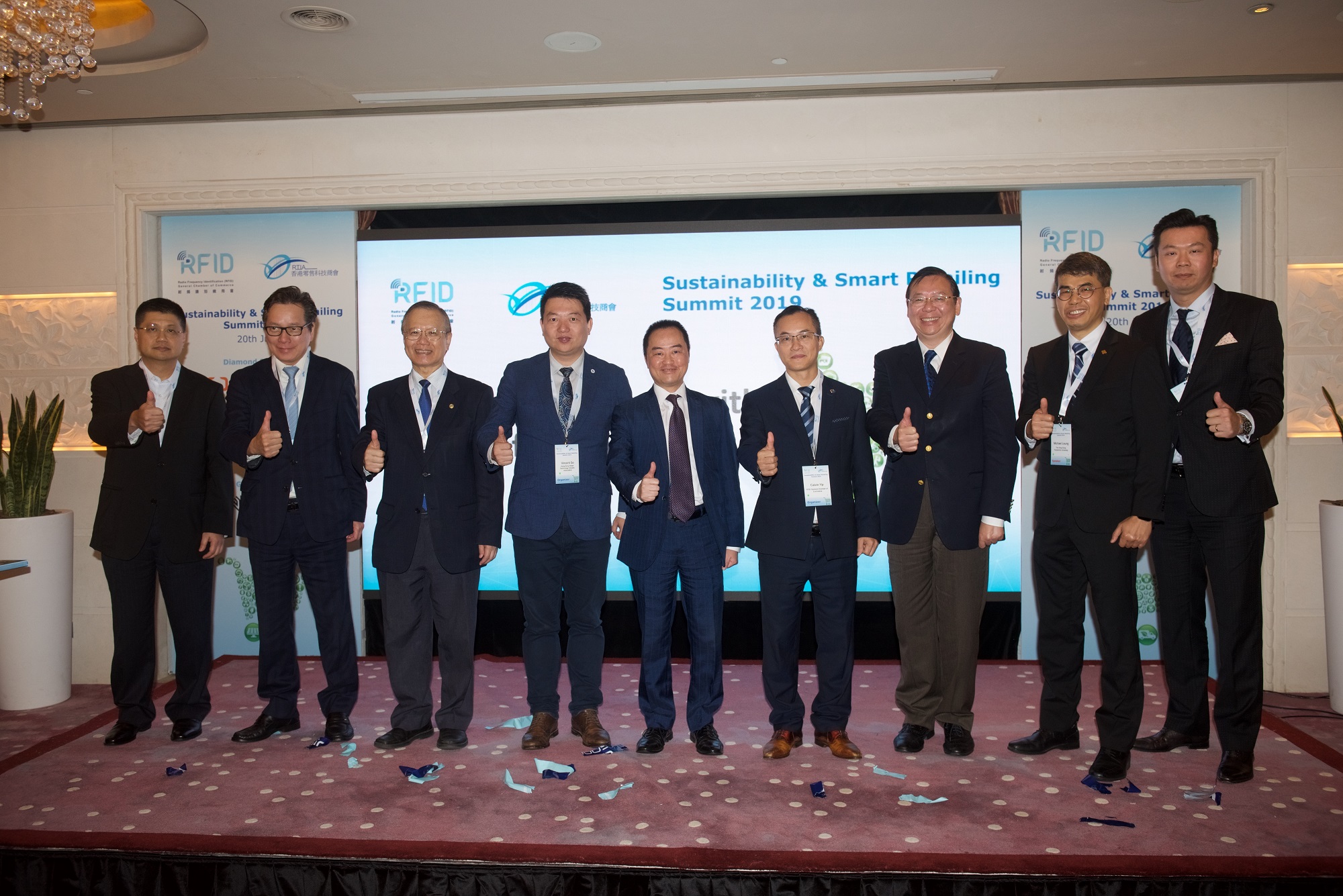 Mr. Tony Wong, Assistant Government Chief Information Officer (Industry Development) (centre), Mr Calvin Yip, Chairman, Radio Frequency Identification General Chamber of Commerce (RFIDGCC) (fourth right), Mr Vincent So, Chairman, Hong Kong Retail Technology Industry Association (HKRTIA) (fourth left), Mr. Simon Wong, Chief Executive Officer, Logistics and Supply Chain MultiTech R&D Centre (third right), Dr. LUI Sun-wing, Honorary Consultant of RFIDGCC, Former Vice-President of the Hong Kong Polytechnic University (third left), Dr. Michael Leung, Director, Industrial Centre, Hong Kong Polytechnic University (second right), Dr Chan Wai-kai, Chief Principal, Hong Kong Baptist University Affiliated School Wong Kam Fai Secondary and Primary School (second left), Mr. Byron Yeung, Honorary Consultant, RFIDGCC (first right), Dr. Stephen Lam, Chief Operating Officer, GS1 Hong Kong (first left) at the “Sustainability & Smart Retailing Summit 2019”.