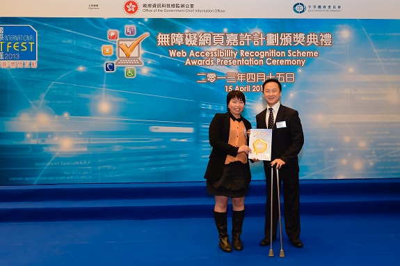 Equal Opportunities Commission member, Mr Nelson Yip, MH (right), presents a Gold Award certificate to the Centre-in-charge of Jockey Club Digital Inclusion Centre, Miss Bertha Lo