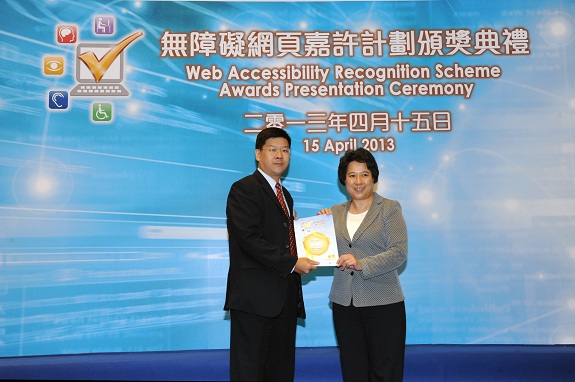 The Permanent Secretary for Commerce and Economic Development (Communications and Technology), Miss Susie Ho, JP (right), presents a Gold Award certificate to the Vice President, IT Services of Arcotect Limited, Mr Victor Cho