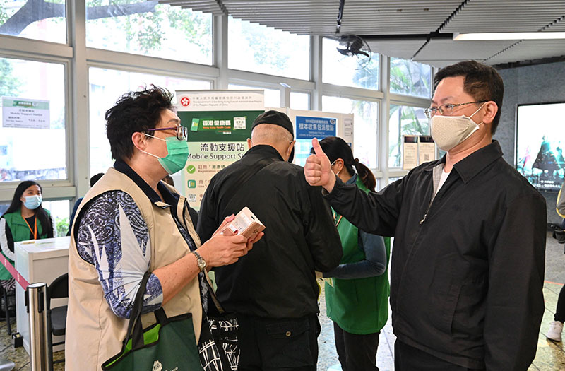 创新及科技局局长薛永恒（右）今日（十二月二十五日）到牛头角港铁站视察，实地了解「香港健康码」流动支援站的运作情况，并与市民交谈，听取他们对外展队的意见。